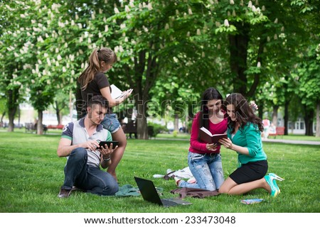 students having lesson outdoor, Students read a book in the park