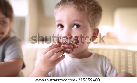 Similar – Image, Stock Photo Little blonde sweet girl is noodles with tomato sauce and smears her face with red sauce with her hand, she holds the small spoon in her hand, over a bowl and looks curiously into the camera, at home in the apartment.