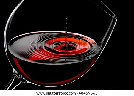 glass of red wine, drops in motion, studio shot
