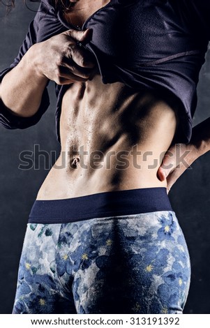 closeup shot of trained female body, abdominal muscles, fitness model abs