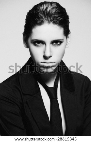 young woman in black vest black tie androgyn looks