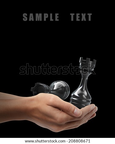 Man hand holding object ( Chess black ) isolated on black background. High resolution
