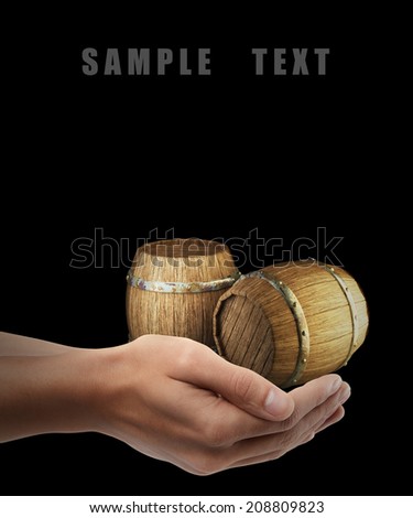 Wooden barrels. Man hand holding object isolated on black background. High resolution