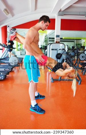 Woman with her personal fitness trainer in the gym