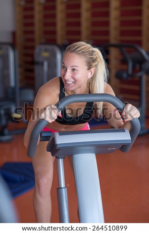 beatiful young woman doing sport spinning with headset in the gym