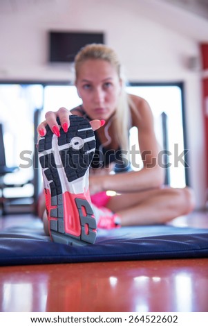 Beautiful young fit woman doing exercises on the floor at the gym