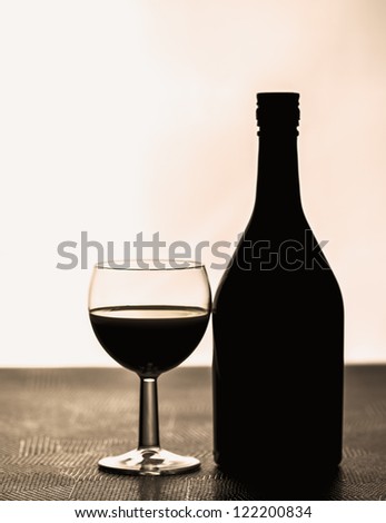 Glass next to a bottle backlit with bright light/Glas next to a bottle/Alcohol drink