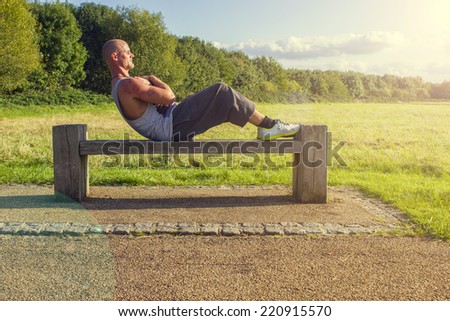 Man doing sit ups on a bench outdoors/Outdoor situps/Fitness photography