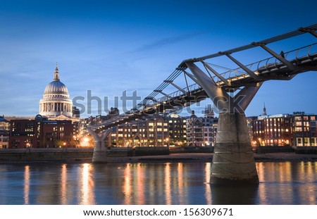 Pretty night time illuminations of St Paul\'s Cathedral and the millennium bridge along the river Thames.