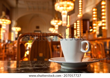 Refreshing coffee with a backdrop of Art Deco lighting in Prague cafe, Czech Republic.