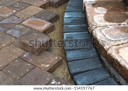 Paving around patio steps with different color tumbled pavers