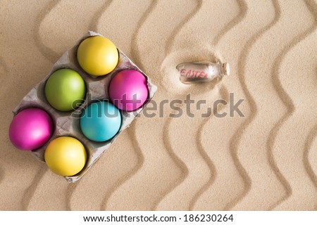 Traditional Easter Egg hunt on a tropical beach with colorful painted eggs hidden on the golden sand with a decorative squiggly wavy pattern of ridged lines with copy space