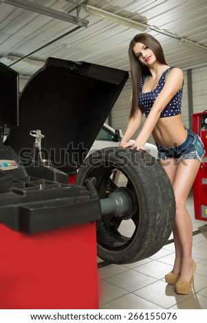 girl mechanic replace tires on wheels