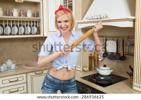 housewife holding a rolling pin. It stands in the kitchen