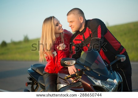 biker man and woman sitting on a motorcycle.