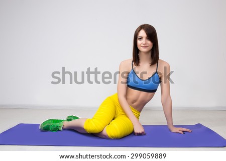 happy cutie athletic girl ,  execute exercise on muscles belly  and smile