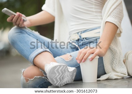 stylish woman drinking coffee to go in a city street