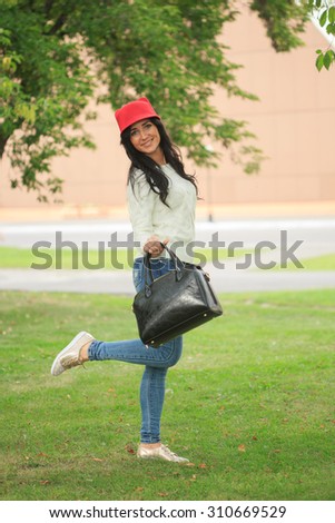 girl in a red hat with ears, holding a bag on the street