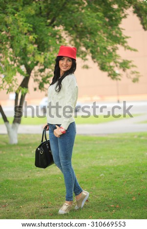 girl in a red hat with ears, holding a bag on the street