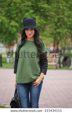girl in a hat with ears, holding a bag on the street
