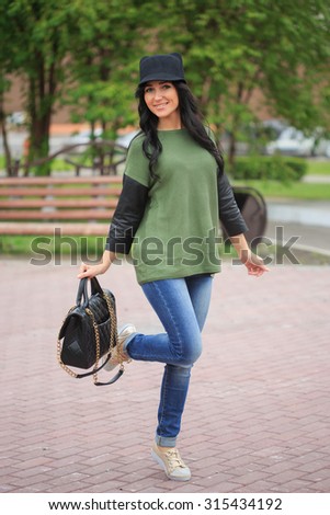 girl in a hat with ears, holding a bag on the street