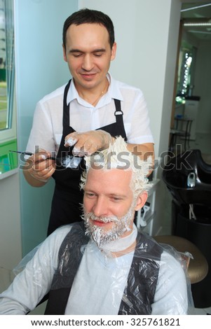 man repaint the hair in a beauty salon