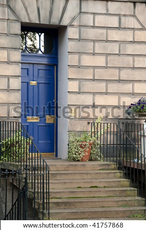 blue front door with stairs and flowers