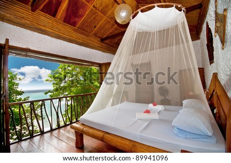 Rural style bedroom with canopy bed with sea view