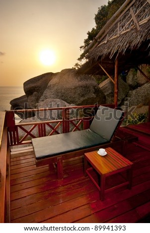 Sunset sunbed on wooden terrace with coffee table