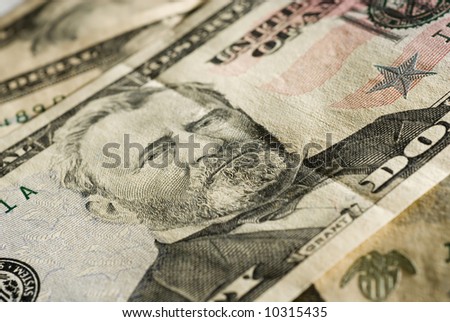Closeup of a fifty dollar bill, focus on Grant\'s face. Side lighting, texture visible