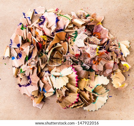 Heap of Color pencil shaves  isolated on brown recycled paper, closeup