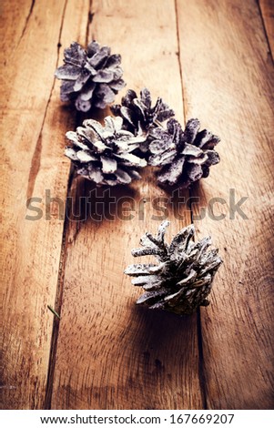 Christmas  decorations on wooden background. Pine cones on old wood board with copyspace for greeting text.