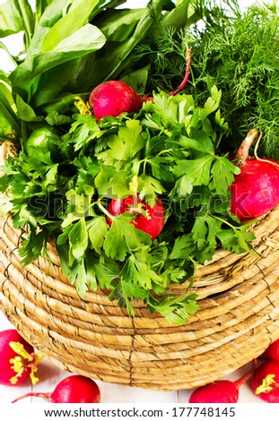 Composition with vegetables and fruits in wicker basket on white. A bunch of fresh different vegetables in a bowl wicker basket on white wooden background