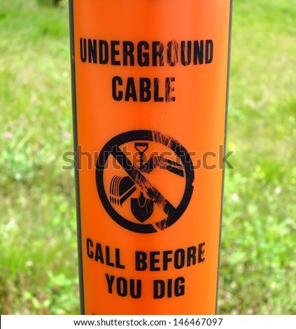 Orange underground cable warning sign.  Call before you dig.