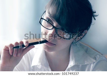 woman holds a pen in his mouth and listen
