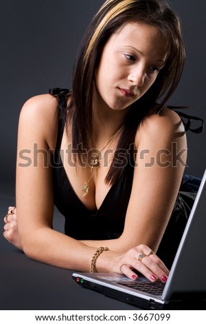 Beautiful young girl checking emails in the laptop