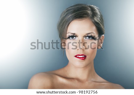 Beautiful woman with red lips and long lashes on dark background