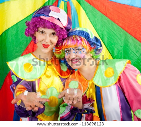 Clowns are making fun with bubbles on colorful background