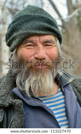 A portrait of the old mongoloid man with grey beard.