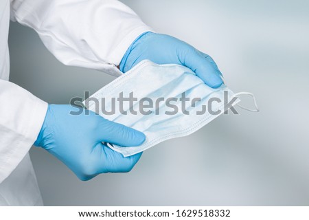 close up of doctor's hand with a medical face mask for protection against infection