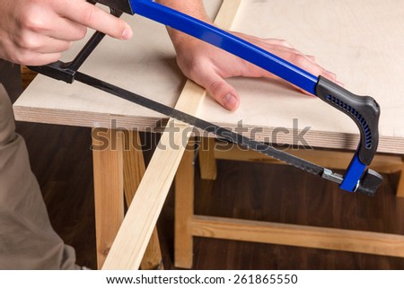 sawing wood with a bow saw