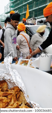 BRESCIA ITALY - APRIL 14: Sikh devotees share food, as per tradition, at the Baisakhi (harvest) Sikh festival, on April 14, 2012 in Brescia