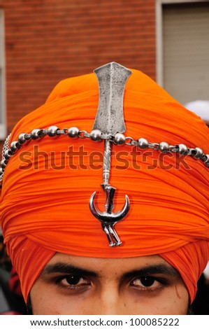 BRESCIA ITALY - APRIL 14: A Sikh devotee wears religious symbols (kirpan) on his turban at the Baisakhi (harvest) Sikh festival, on April 14, 2012 in Brescia