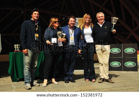 CORTINA (BL) ITALY - SEPTEMBER 1: Giuliano CanÃ?Â© gets the first prize of the Coppa d\'Oro delle Dolomiti historic car race from actors L. Flaherty and S. Autieri, on August 30, 2013 in Cortina (BL)