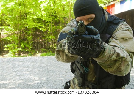 A man with a gun pointing at a target
