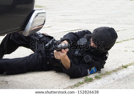 spaciÃ?Â¡lnÃ?Â­ police units lying on the ground with a gun in his hand