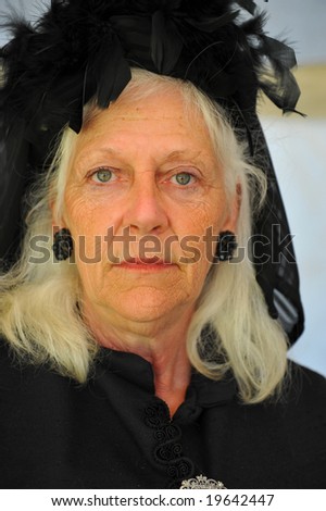 Elderly woman wearing black clothing to indicate mourning. Clothing typical of late 17th century