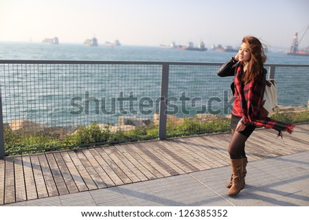 girl take a walk on the wood path in the sun light in hong kong harbor