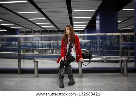 girl waiting someone so long in the modern train platform in hong kong