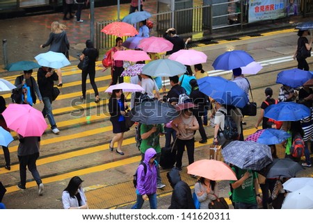 HONG KONG -MAY 13: The crowd of people on the road in rainy day in Central on May 13 2013. 6 p.m. is the peak of rushing hour in central because all people come off work